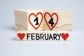 ValentineÃ¢â¬â¢s day composition with wooden calendar. Handwritten February 14th, red hearts.